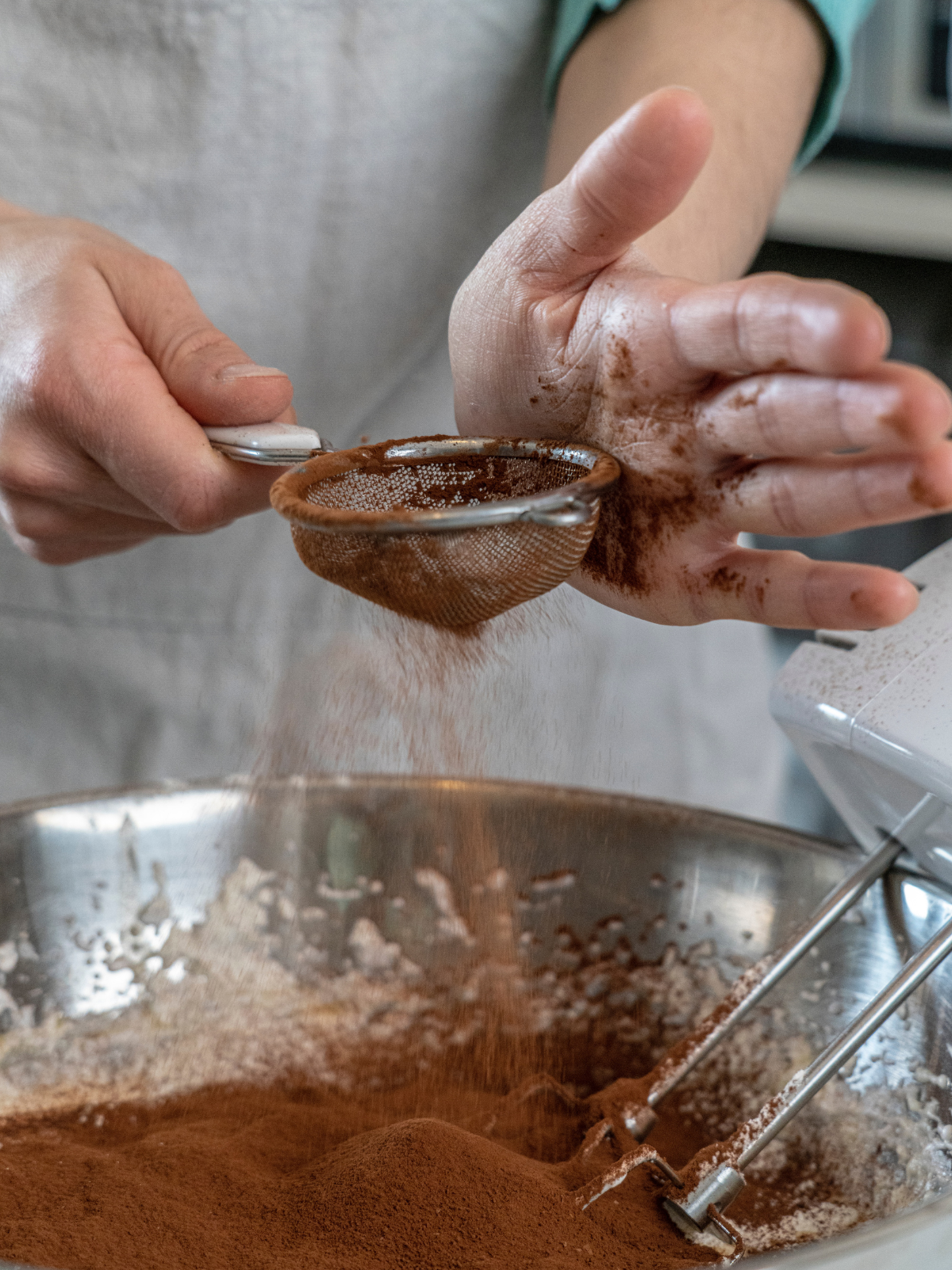 a virtuous woman hard at work sifting cocoa into a batter