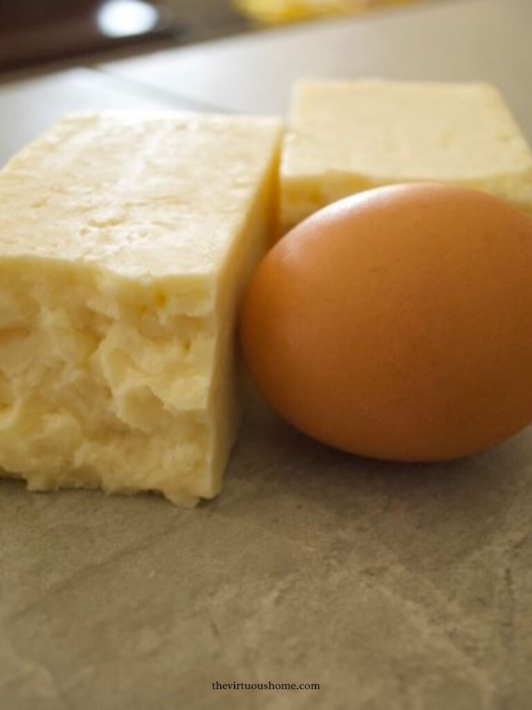 a block of cheddar cheese and an organic egg